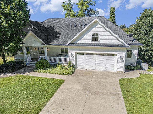 view of front of home with a porch, a garage, central AC unit, and a front lawn