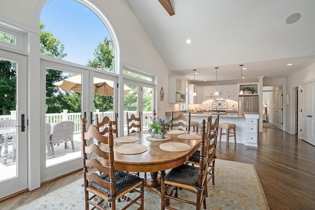 dining space with beam ceiling, dark hardwood / wood-style flooring, high vaulted ceiling, and french doors