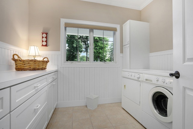 laundry area featuring cabinets, ornamental molding, washer and dryer, and light tile patterned floors