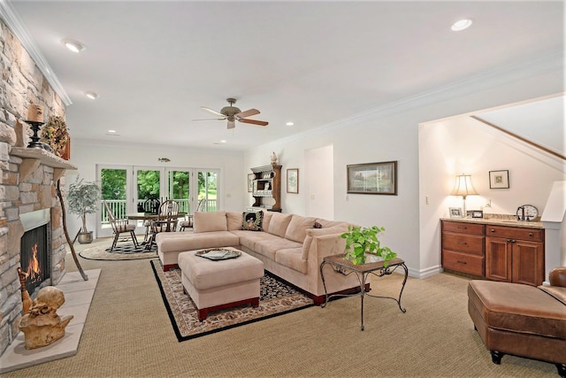 living room with crown molding, a stone fireplace, and light colored carpet