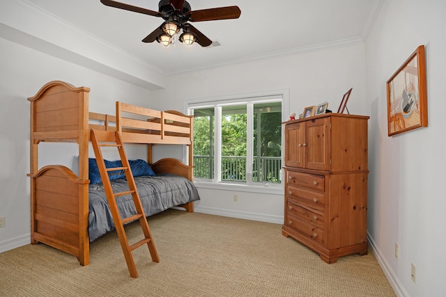 carpeted bedroom featuring crown molding and ceiling fan