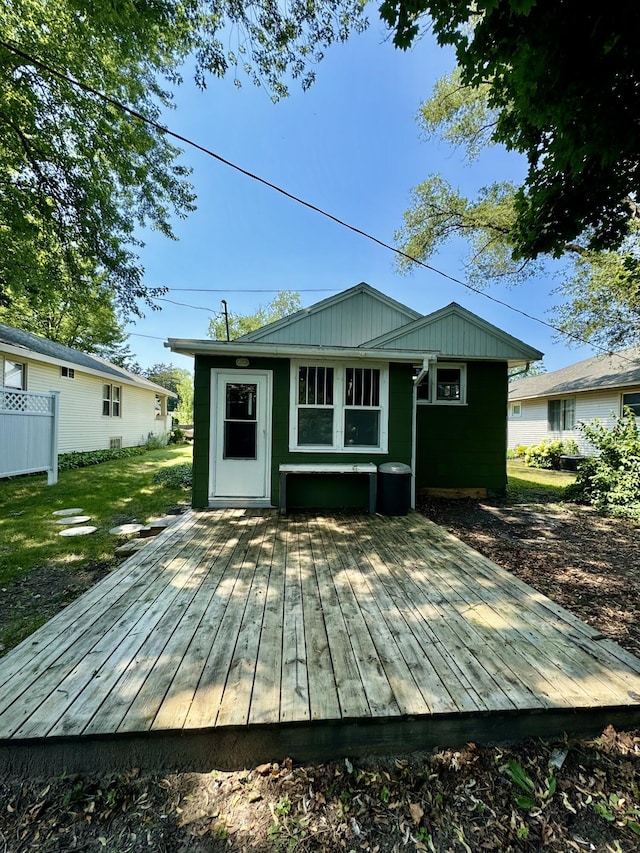 rear view of property with a wooden deck and an outdoor structure