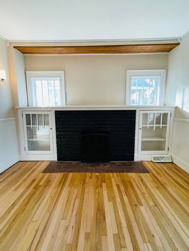 unfurnished living room featuring a fireplace and light hardwood / wood-style floors