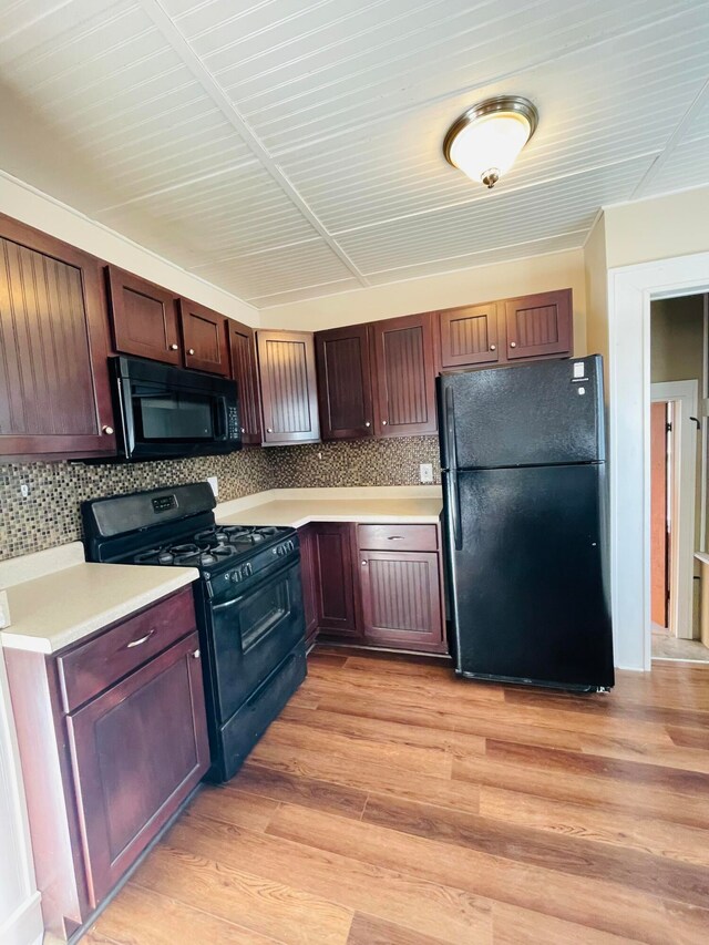 kitchen featuring tasteful backsplash, black appliances, and light hardwood / wood-style floors