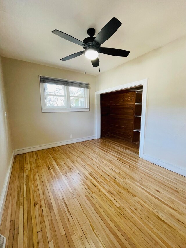 unfurnished bedroom with light wood-type flooring, ceiling fan, and a closet