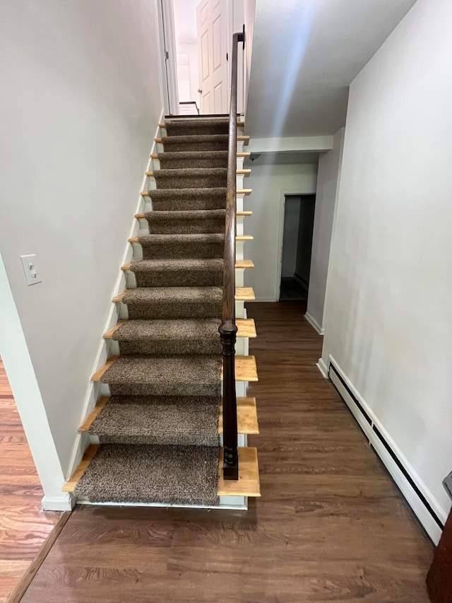 staircase with dark hardwood / wood-style floors and baseboard heating