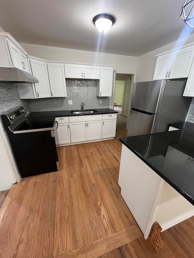 kitchen featuring sink, stainless steel refrigerator, decorative backsplash, light wood-type flooring, and black / electric stove