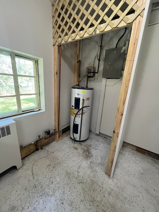 utilities featuring radiator, electric panel, and water heater