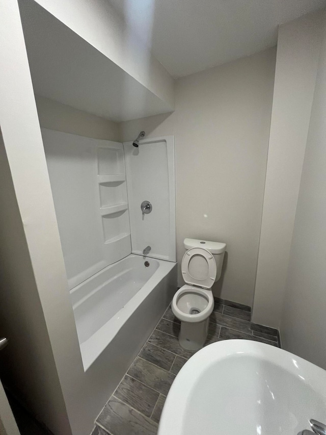 full bathroom with sink, tub / shower combination, and toilet