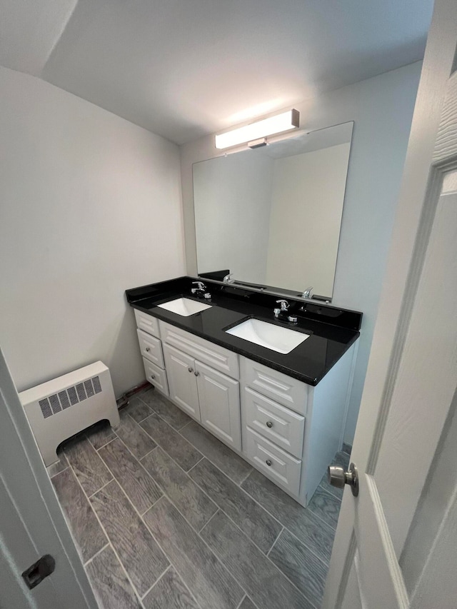 bathroom with dual vanity and radiator heating unit