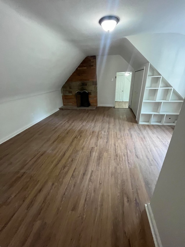 bonus room with hardwood / wood-style flooring and lofted ceiling