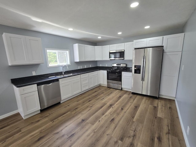 kitchen featuring white cabinetry, stainless steel appliances, dark hardwood / wood-style flooring, and sink