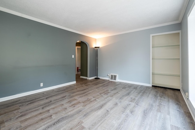 unfurnished room featuring ornamental molding and light wood-type flooring