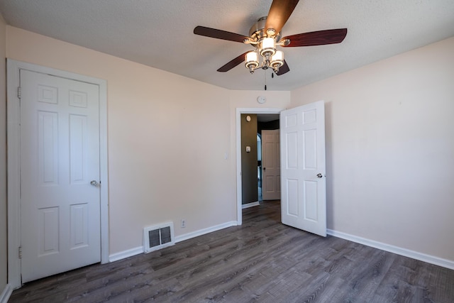 unfurnished bedroom featuring dark wood-type flooring and ceiling fan