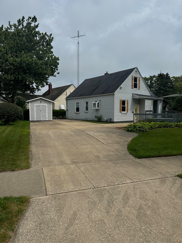 view of front facade featuring covered porch, a front lawn, and a shed