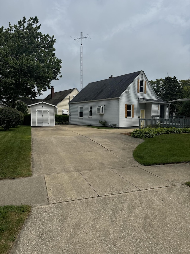 view of front of home featuring a storage unit, an outdoor structure, and a front lawn