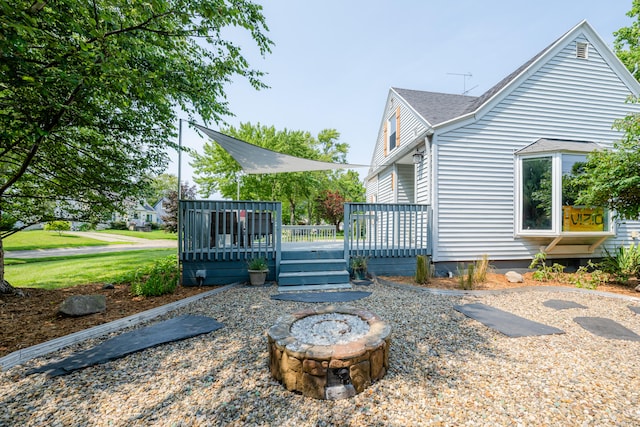 exterior space with a wooden deck and a fire pit