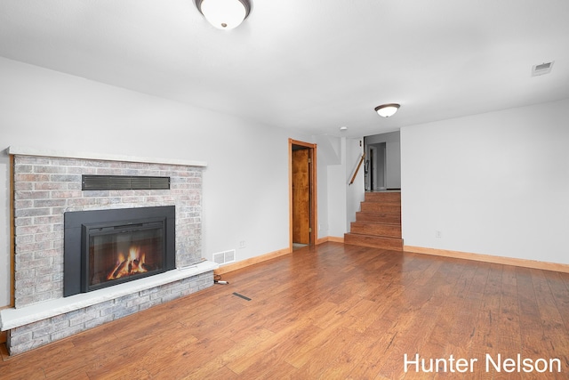 unfurnished living room featuring a fireplace and wood-type flooring