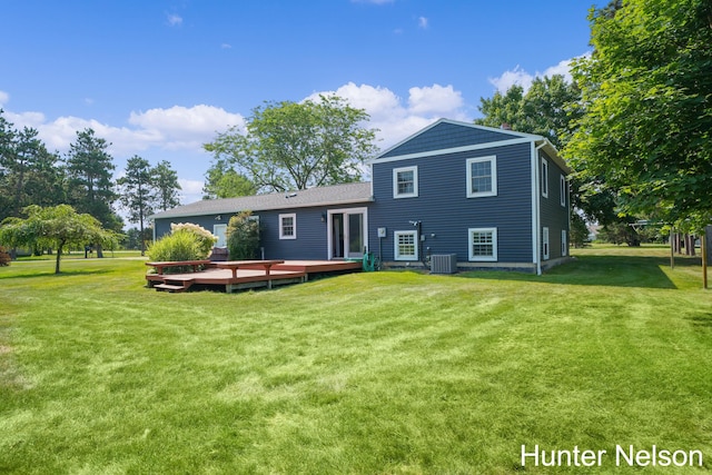 rear view of property with cooling unit, a lawn, and a deck