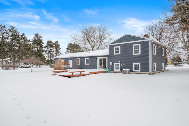 snow covered rear of property with central air condition unit and a wooden deck