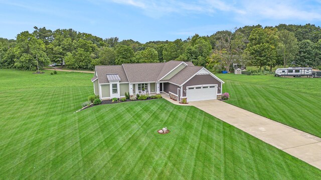 view of front of home with a front yard, concrete driveway, and a garage