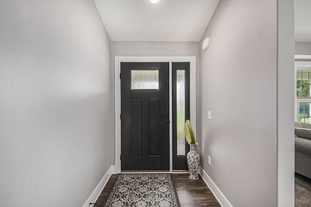 foyer entrance with dark wood-style floors and baseboards