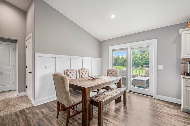 carpeted dining space with high vaulted ceiling