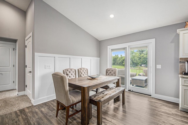 dining space with baseboards, dark wood-type flooring, wainscoting, and vaulted ceiling