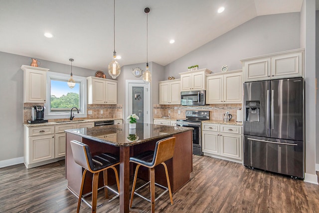 kitchen with appliances with stainless steel finishes, tasteful backsplash, sink, dark hardwood / wood-style floors, and a center island