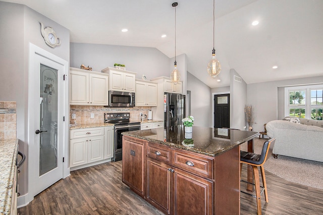 kitchen featuring dark stone counters, stainless steel appliances, tasteful backsplash, a center island, and dark hardwood / wood-style flooring