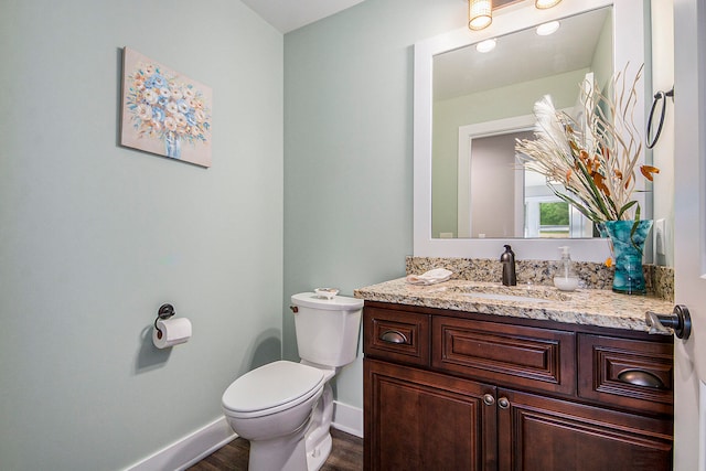 bathroom featuring vanity, toilet, and hardwood / wood-style flooring