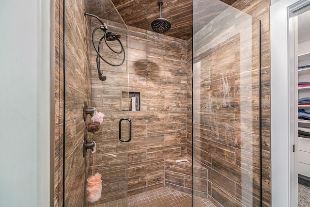 bathroom featuring a spacious closet and a stall shower