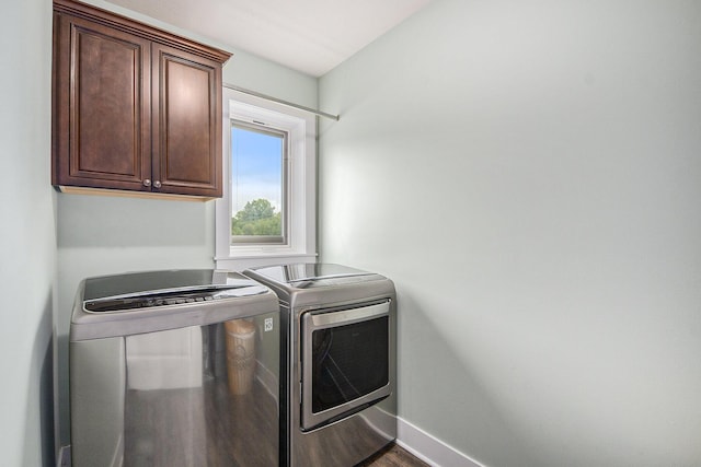 laundry area with cabinet space, washer and dryer, baseboards, and dark wood-style flooring