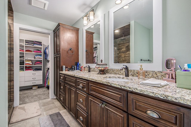 full bathroom with a spacious closet, visible vents, and a sink