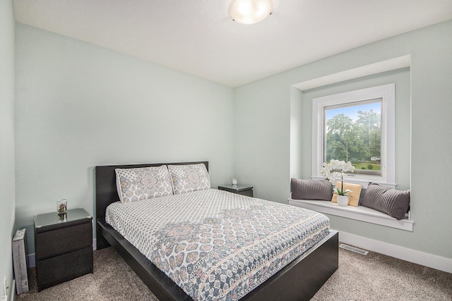 carpeted bedroom featuring visible vents and baseboards