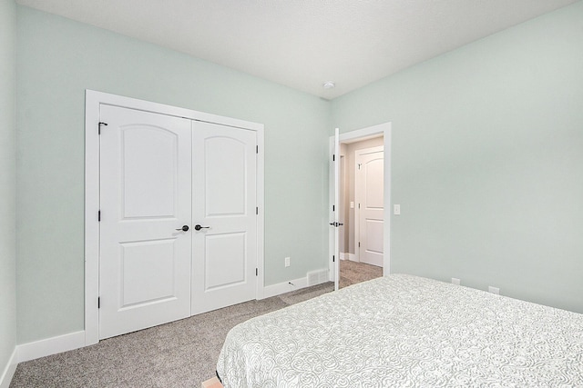 bedroom featuring a closet, visible vents, baseboards, and carpet