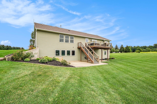 rear view of property featuring a patio, a wooden deck, and a lawn