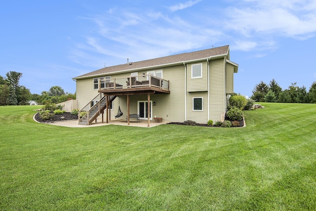 rear view of property featuring a patio area, a lawn, a wooden deck, and stairs