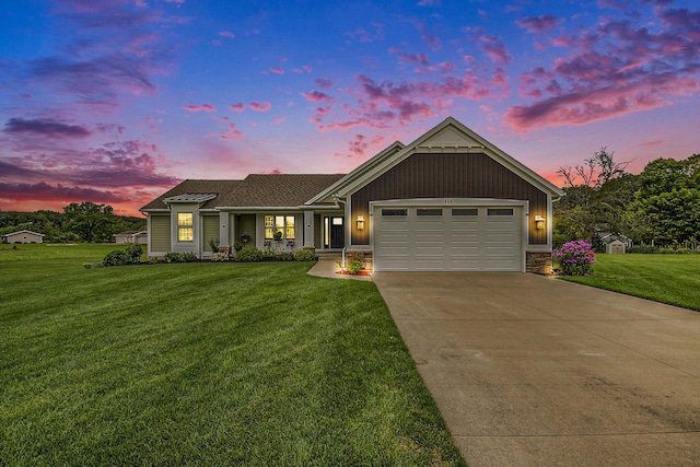 view of front of property featuring an attached garage, board and batten siding, a front yard, stone siding, and driveway