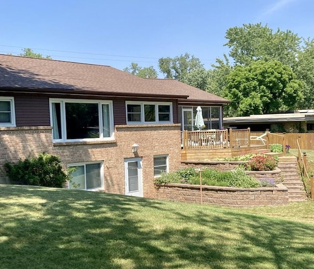 back of house featuring a wooden deck and a lawn