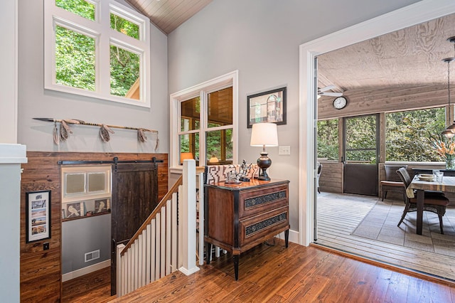 entryway featuring hardwood / wood-style flooring, lofted ceiling, and a barn door