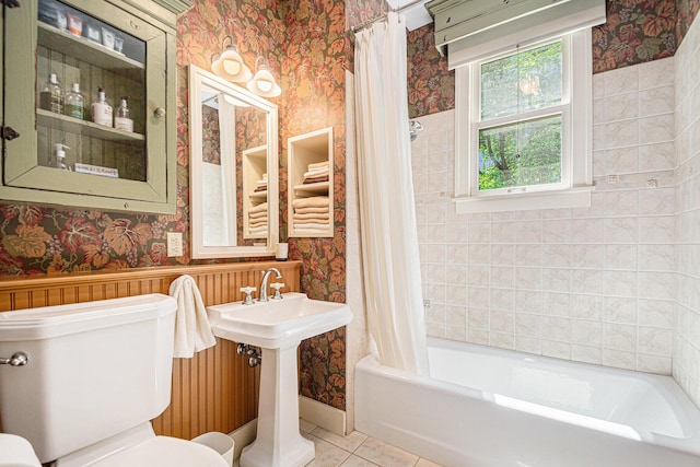 bathroom with tile patterned flooring, shower / tub combo with curtain, and toilet