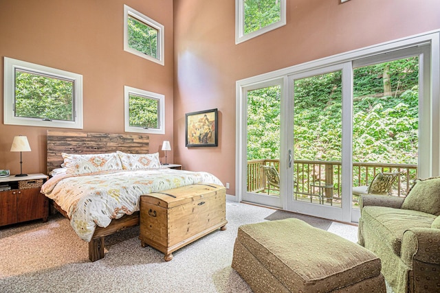 carpeted bedroom featuring a high ceiling and access to outside