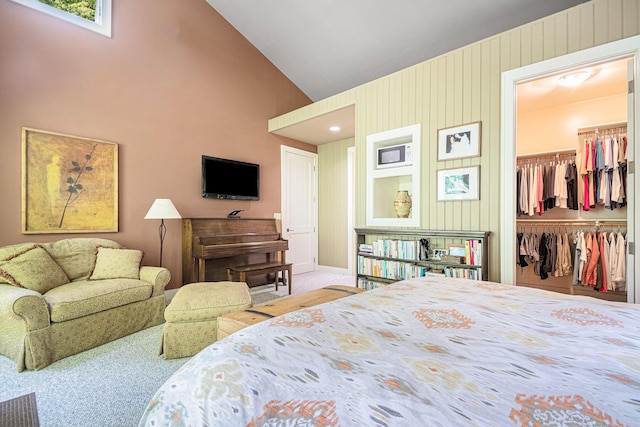 bedroom with lofted ceiling, a walk in closet, a closet, and carpet flooring