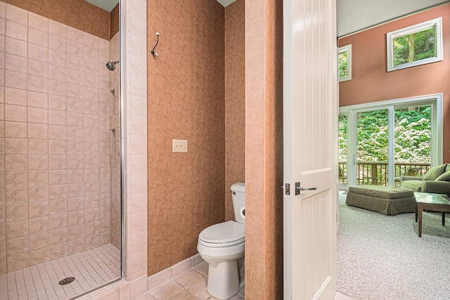 bathroom featuring tile patterned flooring, a shower with door, and toilet