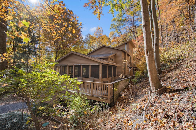 back of property featuring a wooden deck and a sunroom