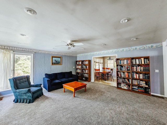 carpeted living room with ceiling fan