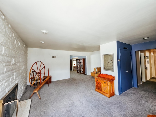 living area featuring carpet and a fireplace