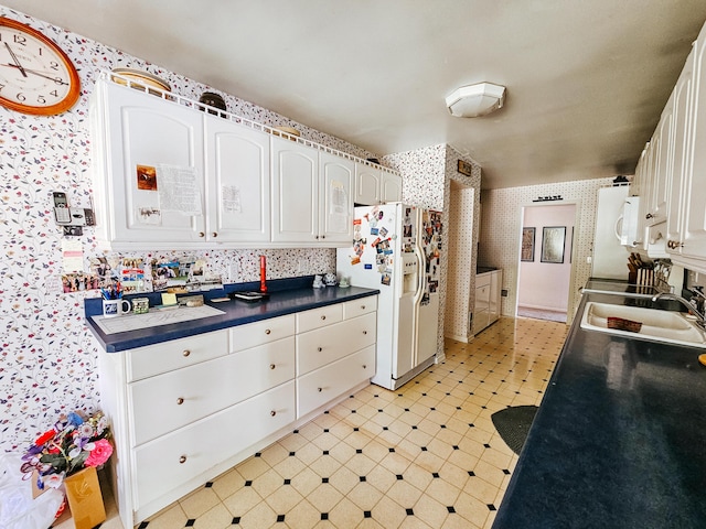 kitchen with white fridge with ice dispenser, sink, and white cabinets