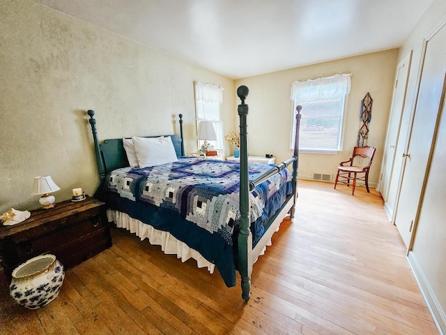 bedroom with light hardwood / wood-style floors and a closet